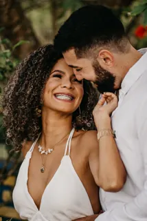 A bride laughing as her husband leans in close.