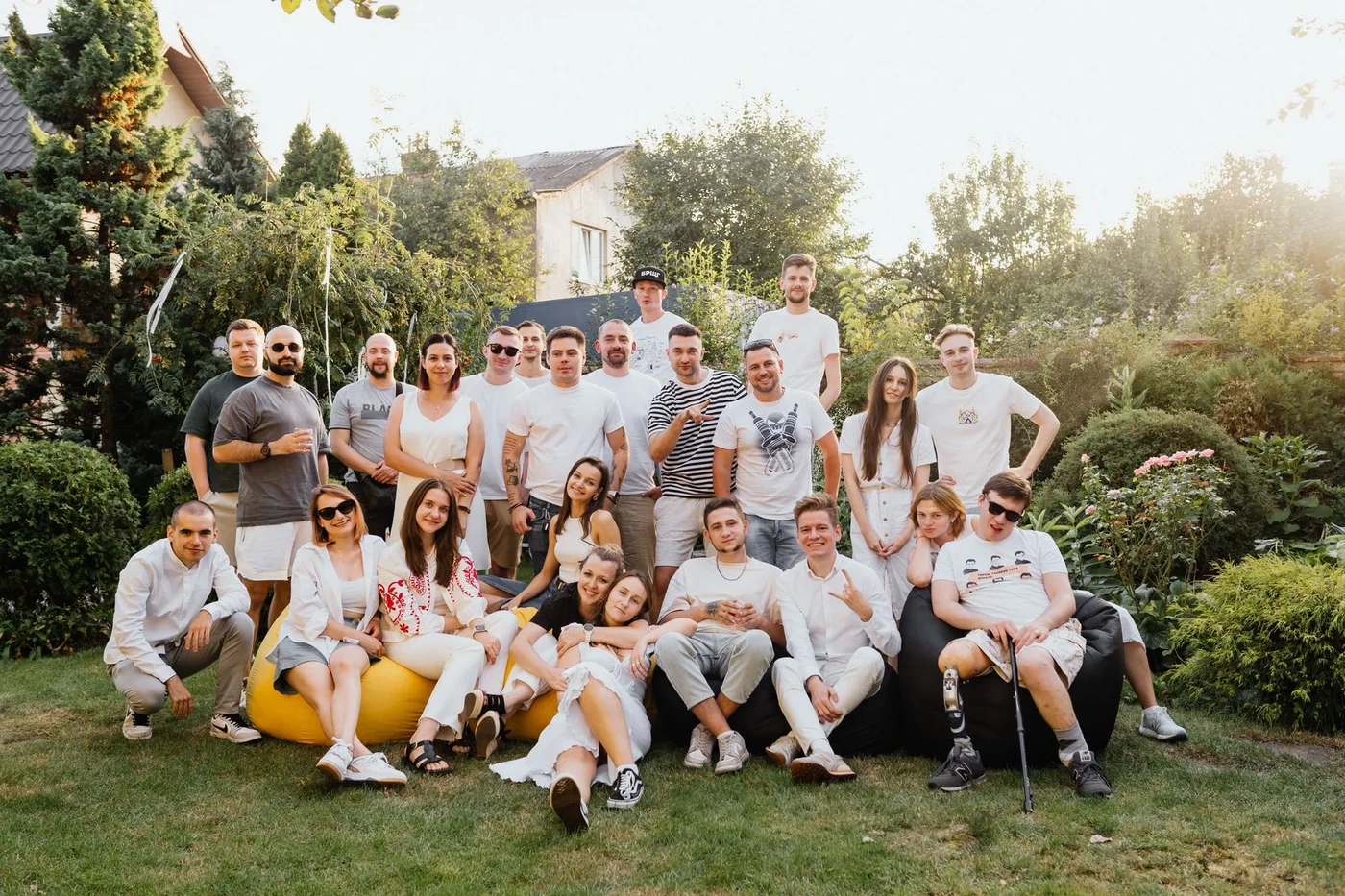 A group relaxing together on a sunny lawn at an outdoor gathering