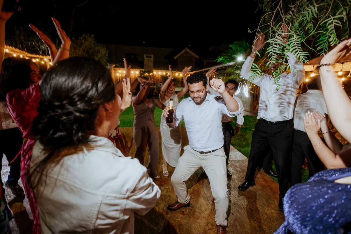 Guests dancing under string lights at a reception